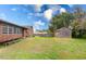 Expansive backyard featuring a storage shed, above ground pool, and lush lawn at 9877 7Th Ave, Orlando, FL 32824