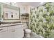 Bathroom with white cabinets, granite countertop, and a tropical shower curtain at 9979 Schroeder Aly, Winter Garden, FL 34787
