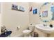 Small bathroom with white pedestal sink, toilet, and Frozen-themed decor at 9979 Schroeder Aly, Winter Garden, FL 34787