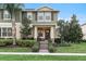 Two-story green house with brown accents, front porch, and landscaped yard at 9979 Schroeder Aly, Winter Garden, FL 34787