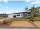 Ranch style home with grey exterior, palm trees, and landscaped yard at 1030 Bel Aire Dr, Daytona Beach, FL 32118