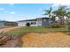 Newly remodeled home with grey exterior, palm trees, and landscaped yard at 1030 Bel Aire Dr, Daytona Beach, FL 32118