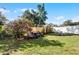 Backyard with two ATVs and flowering camellia bush at 117 Temple St, Deland, FL 32720