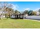 Ranch home with a covered porch, fenced yard, and mature trees at 117 Temple St, Deland, FL 32720