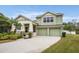 Two-story house with green exterior, two-car garage, and landscaped yard at 14020 Bradbury Rd, Orlando, FL 32828