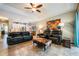 Living room with black leather couches, ottoman, and ceiling fan at 14020 Bradbury Rd, Orlando, FL 32828