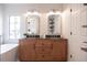 Bright bathroom features a double vanity with wood cabinets, framed mirrors, and modern fixtures at 14217 Sapphire Bay Cir, Orlando, FL 32828