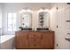 Bathroom with double vanity, wood cabinets, and arched mirrors at 14217 Sapphire Bay Cir, Orlando, FL 32828