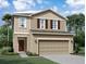 Two-story house with beige siding, brown accents, and a two-car garage at 1457 Dalkeith Cv, Sanford, FL 32771