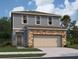 Two-story house with gray siding, stone accents, and a two-car garage at 1457 Dalkeith Cv, Sanford, FL 32771