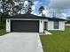 Modern house with dark gray garage doors and a neatly landscaped front yard at 1590 West Pkwy, Deland, FL 32724