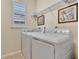 Bright laundry room with washer, dryer, and ample shelving at 161 Old Moss Cir, Deland, FL 32724