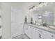 Double vanity bathroom with granite countertop and large mirror at 2102 Gopher Tortoise Ter, Oakland, FL 34787