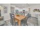 Farmhouse style dining area with wood table and kitchen view at 2102 Gopher Tortoise Ter, Oakland, FL 34787