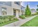 Row of townhomes with light blue siding, landscaping, and a paved walkway at 2102 Gopher Tortoise Ter, Oakland, FL 34787