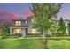 Two-story townhome with light blue siding, landscaping, and lit windows at dusk at 2102 Gopher Tortoise Ter, Oakland, FL 34787