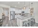 Modern kitchen with white cabinets, granite counters, and island seating at 2102 Gopher Tortoise Ter, Oakland, FL 34787