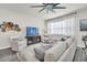 Bright living room features a comfy sectional sofa, two armchairs, and a large TV at 2102 Gopher Tortoise Ter, Oakland, FL 34787