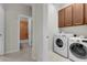 Bright laundry room with washer, dryer, and cabinets at 219 Blue Cypress Dr, Groveland, FL 34736