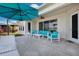 Relaxing patio with turquoise furniture and umbrella at 219 Blue Cypress Dr, Groveland, FL 34736