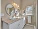 Bathroom with dual vanity, white cabinets, oval mirrors, and a walk-in shower with glass door at 233 Bluejay Way, Orlando, FL 32828