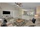 Inviting living room with ceiling fan, neutral walls, stylish furniture, and seamless flow to the kitchen area at 233 Bluejay Way, Orlando, FL 32828