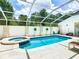 Refreshing pool and spa with screened enclosure and patio seating at 3211 Sunrise Walk, Kissimmee, FL 34747