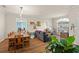 Open concept dining room with a rustic wooden table and chairs, adjacent to a living area at 33925 Terragona Dr, Sorrento, FL 32776