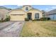 Beautiful two-story house with a yellow facade, a two-car garage, and a nicely landscaped lawn at 33925 Terragona Dr, Sorrento, FL 32776