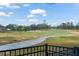 Scenic view of a golf course from a backyard deck, showcasing lush greens and mature trees at 33925 Terragona Dr, Sorrento, FL 32776