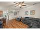 Spacious living room with hardwood floors and fan, connecting to the kitchen at 33925 Terragona Dr, Sorrento, FL 32776