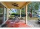 A covered patio features a ceiling fan, a table with four chairs, and a view of the backyard at 33925 Terragona Dr, Sorrento, FL 32776