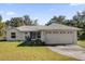 One-story house with attached garage and landscaped lawn at 38100 Ricker Dr, Lady Lake, FL 32159