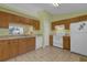 Galley style kitchen with wood cabinets and white appliances at 38100 Ricker Dr, Lady Lake, FL 32159