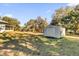 Grey storage shed in sunny backyard setting at 38100 Ricker Dr, Lady Lake, FL 32159