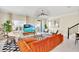 Bright living room with orange couch and large TV at 4299 Paragraph Dr, Kissimmee, FL 34746