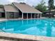 Community pool with adjacent clubhouse and patio area at 5801 Windhover Dr # A01, Orlando, FL 32819