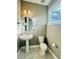 Small, updated bathroom with pedestal sink, toilet, and single window at 5814 Bimini Twist Loop, Orlando, FL 32819