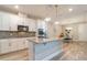 Modern kitchen with island, stainless steel appliances, and light wood floors at 5814 Bimini Twist Loop, Orlando, FL 32819