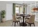 Cozy dining area featuring a round table, four chairs, a modern chandelier, and light green curtains at 609 Bayhawk St, Debary, FL 32713