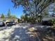 Wide backyard with ample parking, gravel, mature trees, and an outdoor seating area at 6254 Balboa Dr, Orlando, FL 32808