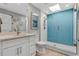 Contemporary bathroom features a sleek vanity and walk-in shower with blue subway tile at 6912 S Atlantic Ave, New Smyrna Beach, FL 32169