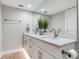 Modern bathroom features double sinks, a large mirror, white cabinetry, and a decorative plant at 6912 S Atlantic Ave, New Smyrna Beach, FL 32169