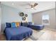 Charming bedroom with two twin beds, blue bedding, ceiling fan, and decor at 6912 S Atlantic Ave, New Smyrna Beach, FL 32169