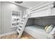 Bright bedroom features a bunk bed, window with blinds, and hardwood flooring at 6912 S Atlantic Ave, New Smyrna Beach, FL 32169