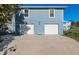 A close-up of a blue two-story home featuring a two-car garage and concrete driveway at 6912 S Atlantic Ave, New Smyrna Beach, FL 32169