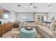 Bright and airy living room with a large sectional sofa, plush ottoman, and stylish decor at 6912 S Atlantic Ave, New Smyrna Beach, FL 32169