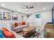 Inviting living room with stylish sofas, unique artwork, and a modern ceiling fan at 6912 S Atlantic Ave, New Smyrna Beach, FL 32169