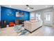 Modern living room featuring a stylish blue accent wall, comfortable sofa, and tiled flooring at 6912 S Atlantic Ave, New Smyrna Beach, FL 32169