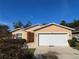 House exterior featuring a two-car garage and well-maintained lawn at 7375 Holly Creek Rd, Mount Dora, FL 32757